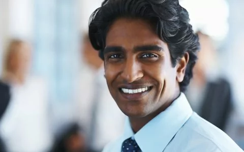 dark haired man smiling with white teeth