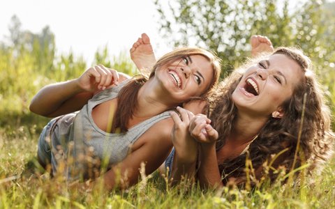 two women laughing in field