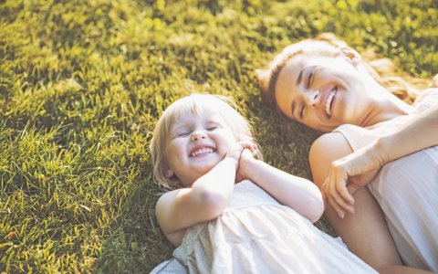 woman and child lying on grass