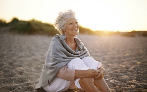 older woman sitting on beach