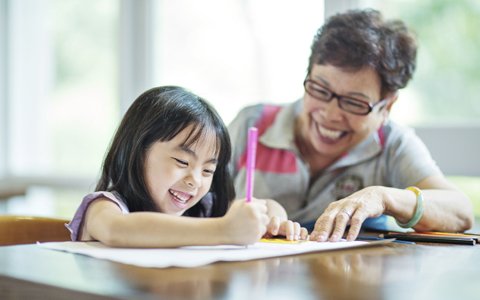 grandparent helping child with homework