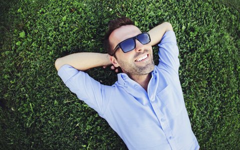 man relaxing in grass smiling