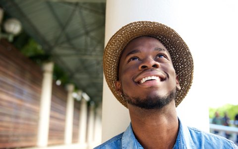 man in hat looking up and smiling