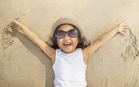 young girl lying on beach