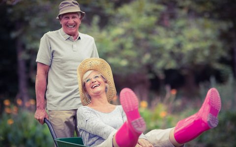 older couple playing with wheelbarrow