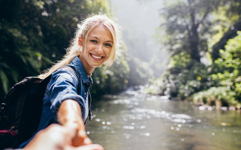 woman leading person by hand and smiling